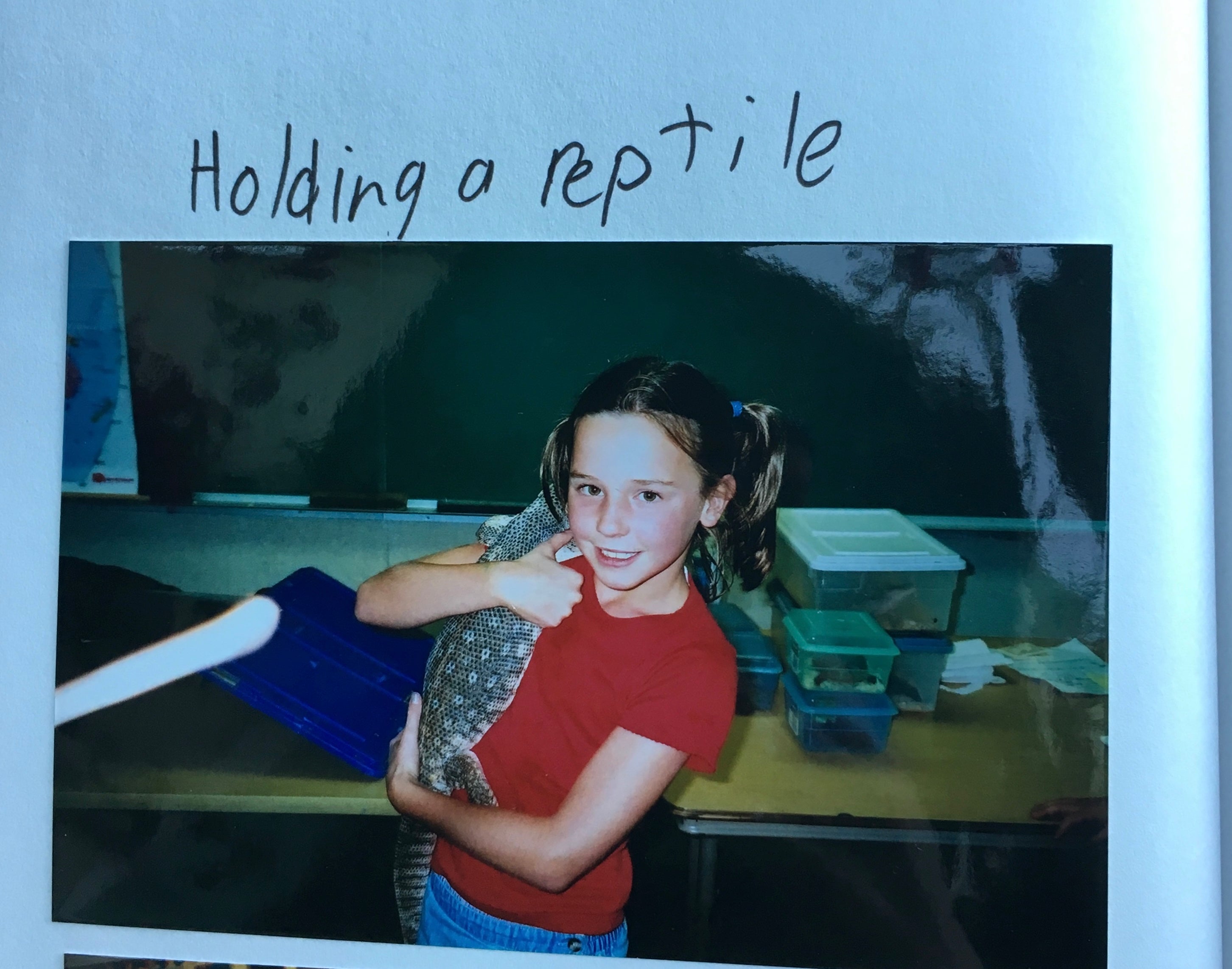 photo of a young girl holding a reptile