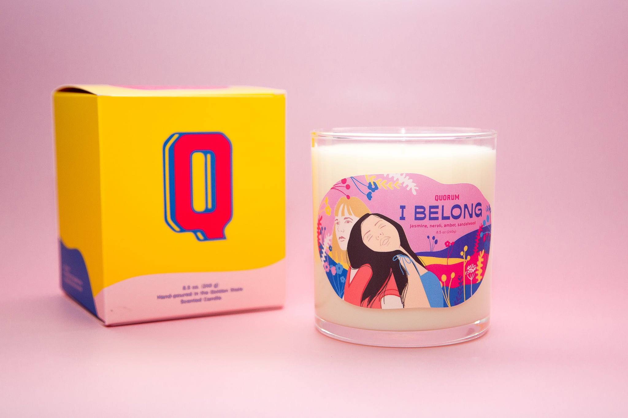 photograph of the Belong affirmation candle on a pink background
